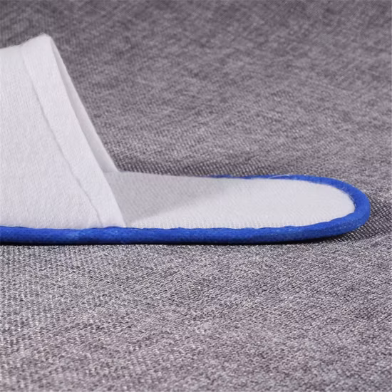 Zapatilla desechable con franja azul para habitación de hotel